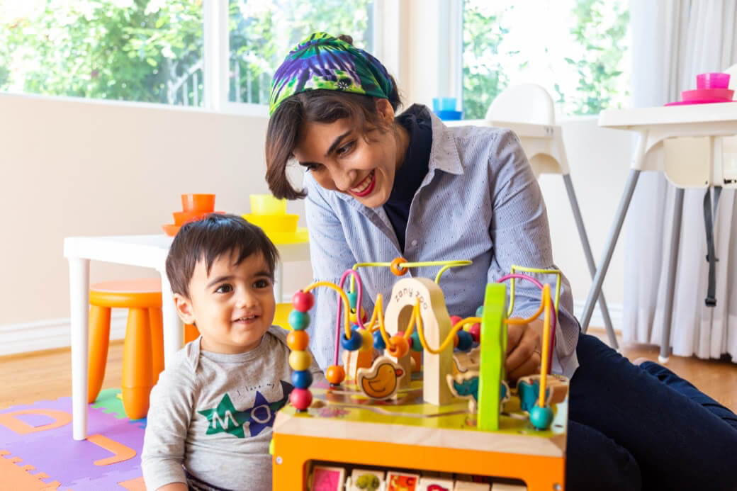 A caregiver and a young child playing together at home