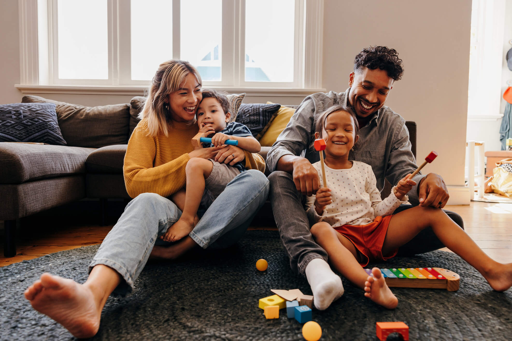 A family playing together with toys on the living room floor
